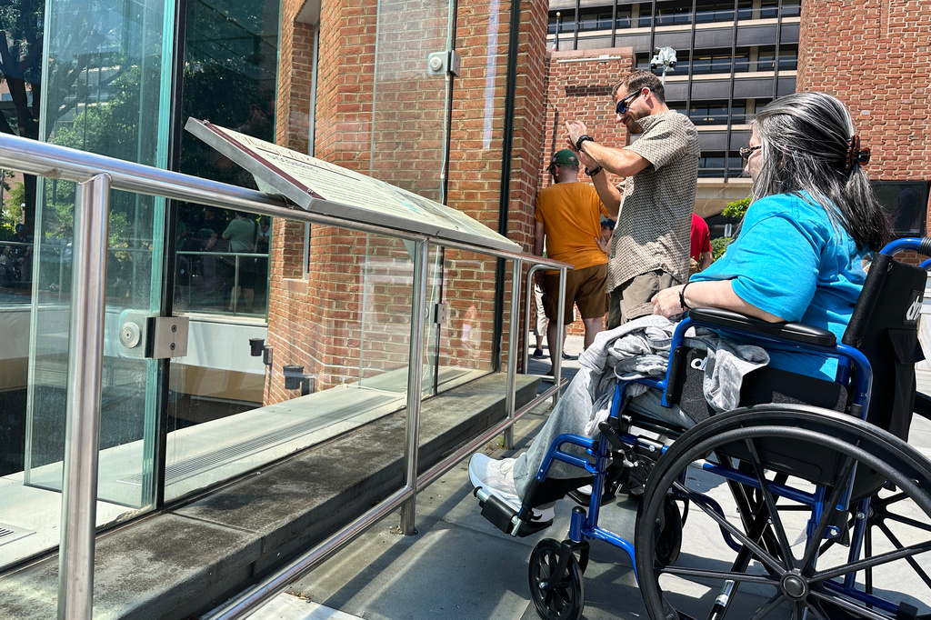 Visitors view the reinstalled educational panels about slavery at the site of President George Washington's home in Philadelphia, Wednesday, July 15, 2026. (AP Photo/Tassanee Vejpongsa)