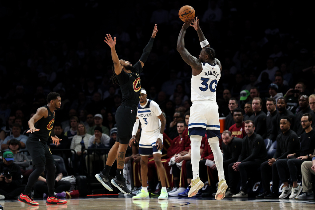 Minnesota Timberwolves forward Julius Randle, right, shoots over Cleveland Cavaliers guard Darius Garland (10) during the first half of an NBA basketball game, Thursday, Jan. 8, 2026, in Minneapolis. (AP Photo/Matt Krohn)