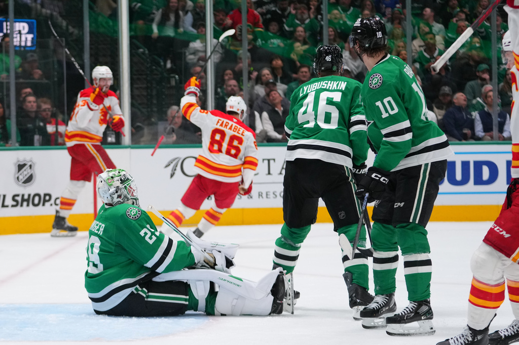 Calgary Flames left wing Joel Farabee (86) reacts after scoring a goal on Dallas Stars goaltender Jake Oettinger (29) during the second period of an NHL hockey game Tuesday, April 7, 2026, in Dallas. (AP Photo/Julio Cortez)