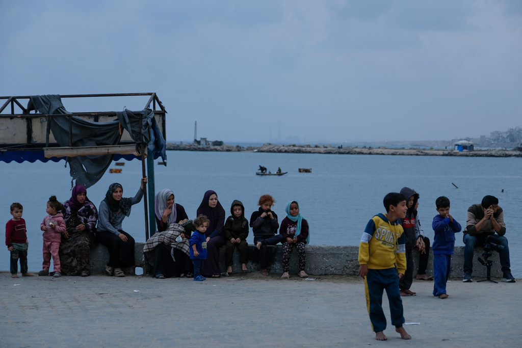 Palestinians sit on the pavement by the Mediterranean Sea in the port of Gaza City, Saturday, Dec. 6, 2025. (AP Photo/Jehad Alshrafi)