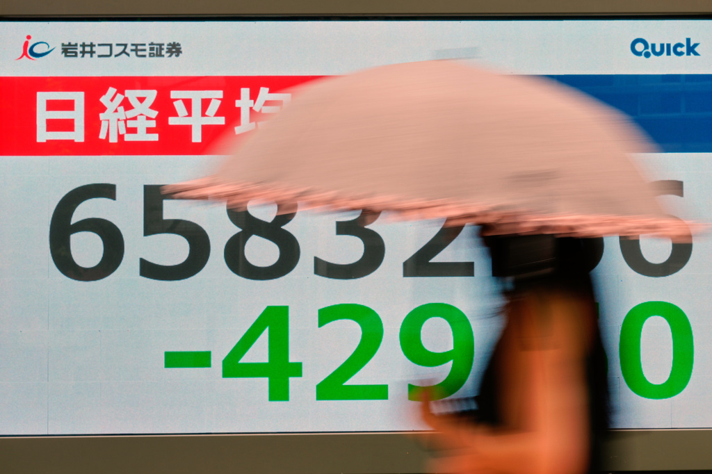 A person walks near an electronic stock board showing Japan's Nikkei index at a securities firm Thursday, Aug. 27, 2026, in Tokyo. (AP Photo/Eugene Hoshiko)