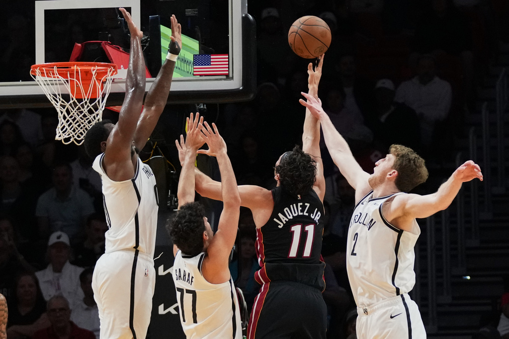 Miami Heat forward Jaime Jaquez Jr. (11) shoots over Brooklyn Nets guard Ben Saraf (77) and forward Danny Wolf (2) during the first half of an NBA basketball game, Tuesday, March 3, 2026, in Miami. (AP Photo/Lynne Sladky)