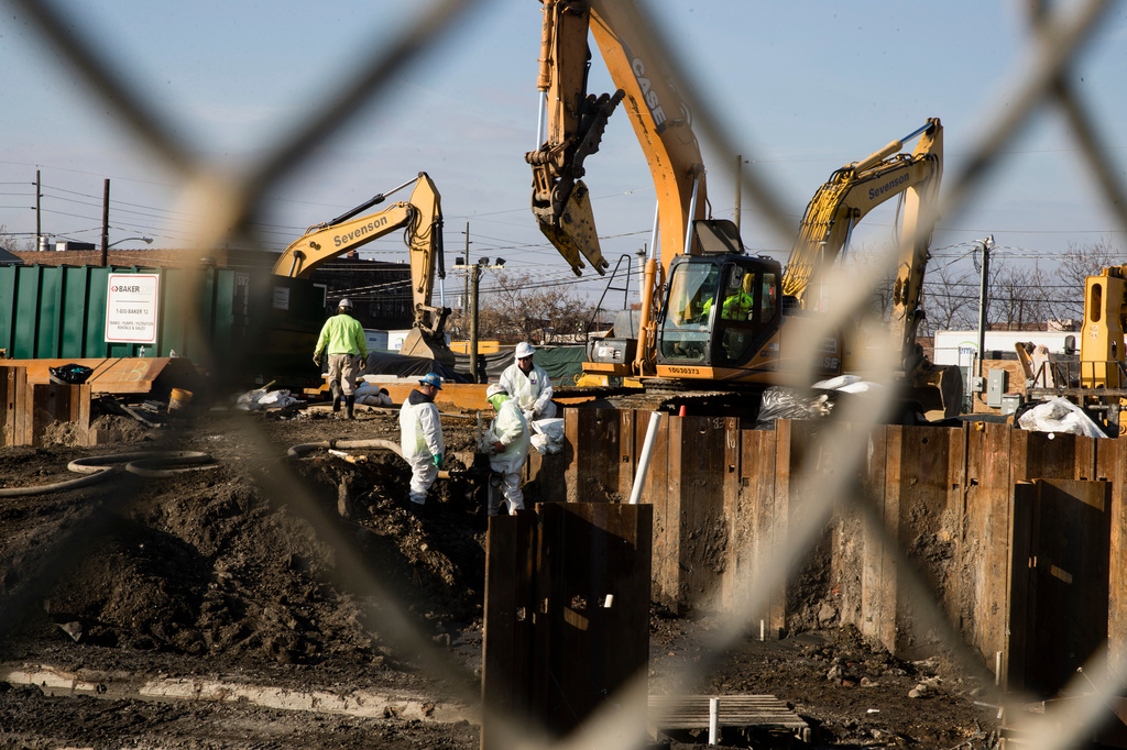 FILE - People in protective clothing work at the Martin Aaron Inc. Superfund site in Camden, N.J, Dec. 11, 2017. (AP Photo/Matt Rourke, File)
