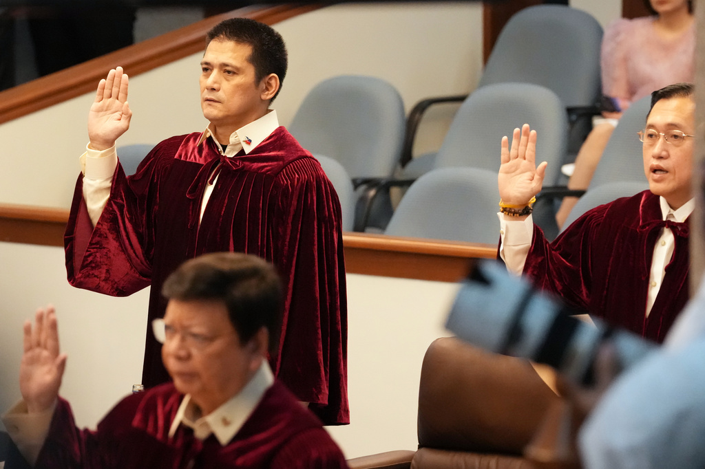 Philippine senator Robin Padilla, left, and Christopher "Bong" Go takes oath as they convene as an impeachment court for the trial of Vice President Sara Duterte at the Philippine senate, Monday, May 18, 2026, in Pasay, Philippines. (AP Photo/Aaron Favila)