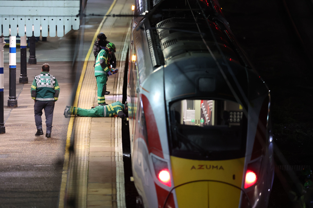 Emergency personnel inspect a train at the Huntingdon, England, train station in Cambridgeshire after people were stabbed Saturday, Nov. 1, 2025. (Chris Radburn/PA via AP)