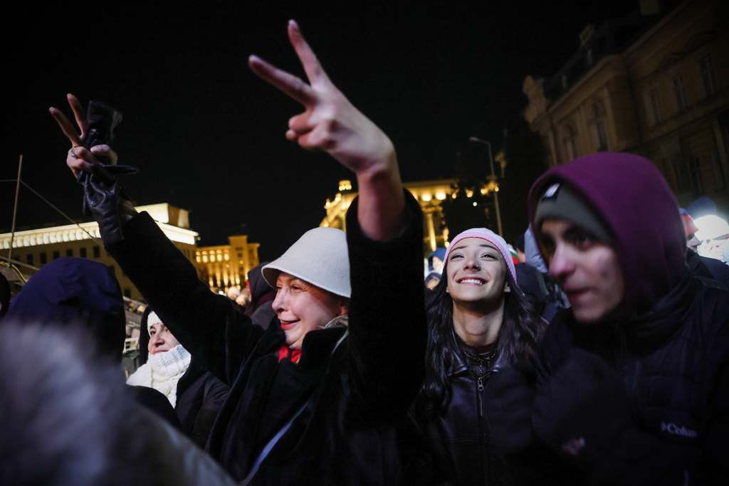 Bulgarians sing and shout as they celebrate the New Year and Bulgaria's adoption of the euro in front of the Bulgarian National Bank in Sofia, Bulgaria, Wednesday, Dec. 31, 2025. (AP Photo/Valentina Petrova)