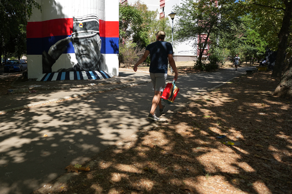A man walks by a mural that shows former Bosnian Serb wartime general Ratko Mladic in Belgrade, Serbia, Wednesday, Sept. 2, 2026. (AP Photo/Darko Vojinovic)