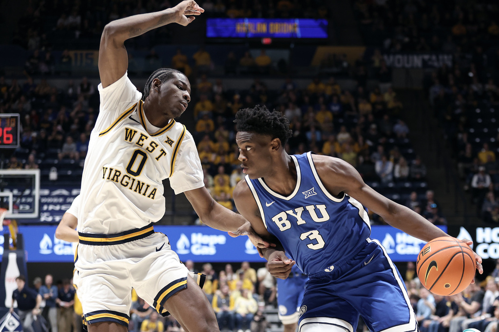 BYU forward AJ Dybantsa (3) is defended by West Virginia forward Brenen Lorient (0) during the first half of an NCAA college basketball game Saturday, Feb. 28, 2026, in Morgantown, W.Va. (AP Photo/Kathleen Batten)