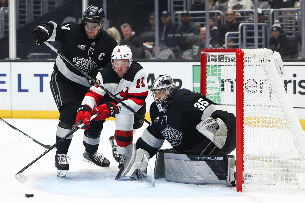 Los Angeles Kings center Anze Kopitar, left, New Jersey Devils right wing Stefan Noesen (11), and Los Angeles Kings goaltender Darcy Kuemper (35) battle for the puck during the first period of an NHL hockey game, Saturday, Nov. 1, 2025, in Los Angeles. (AP Photo/Jessie Alcheh)
