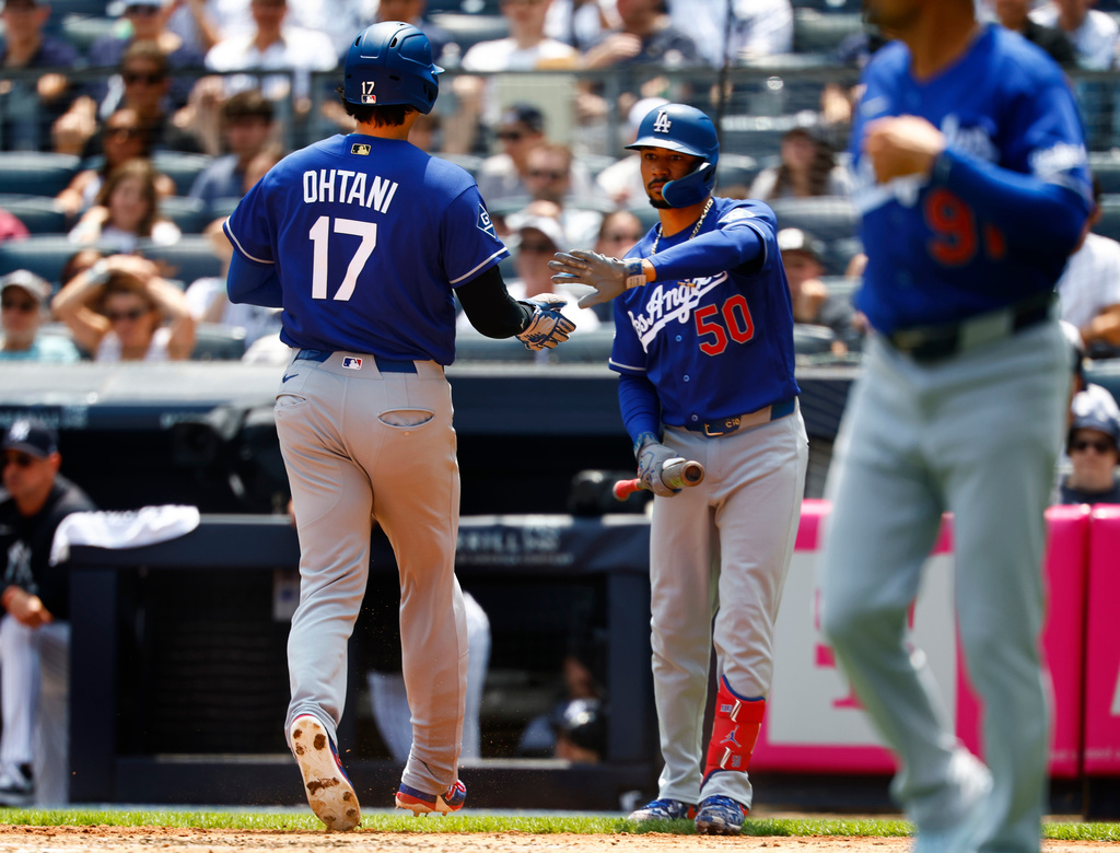 Los Angeles Dodgers' Mookie Betts (50) greets Shohei Ohtani (17) after Ohtani scored against the New York Yankees during the third inning of the first game of a baseball doubleheader, Sunday, July 19, 2026, in New York. (AP Photo/Noah K. Murray)