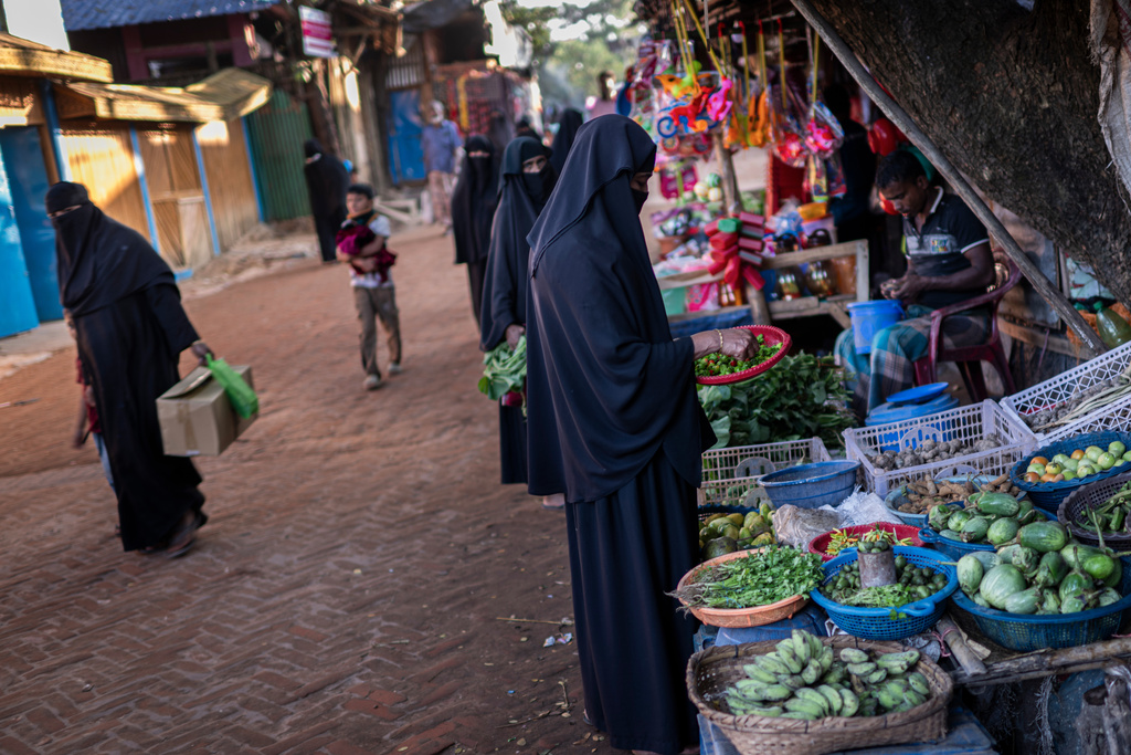 Rohingya refugee women buy vegetables from street vendors in the Rohingya refugee camp in Cox's Bazar, Bangladesh, Monday, Nov. 24, 2025. (AP Photo/Mahmud Hossain Opu)