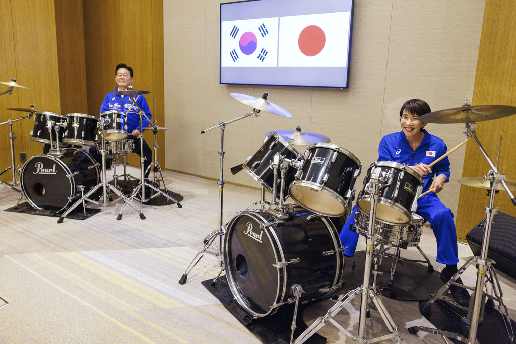 In this photo released on the official website of Prime Minister's Office of Japan, Japanese Prime Minister Sanae Takaichi, right, and South Korean President Lee Jae Myung play drump together after their talks in Nara, western Japan Tuesday, Jan. 13, 2026. (Prime Minister's Office of Japan via AP)