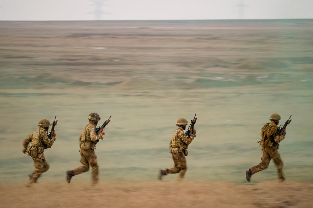 FILE- Servicemen run during the Steadfast Dart 2025 exercise, involving some 10,000 troops in three different countries from nine nations, representing the largest NATO operation planned this year, at a training range in Smardan, eastern Romania, Wednesday, Feb. 19, 2025. (AP Photo/Vadim Ghirda, file)
