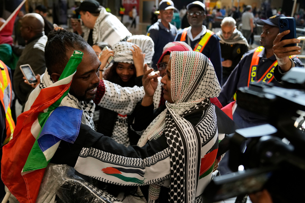 Ebrahim Peters, left, an activist embraces his family member after returning home at OR Tambo International Airport, in Johannesburg, South Africa, Saturday, May 23, 2026. (AP Photo/Themba Hadebe)