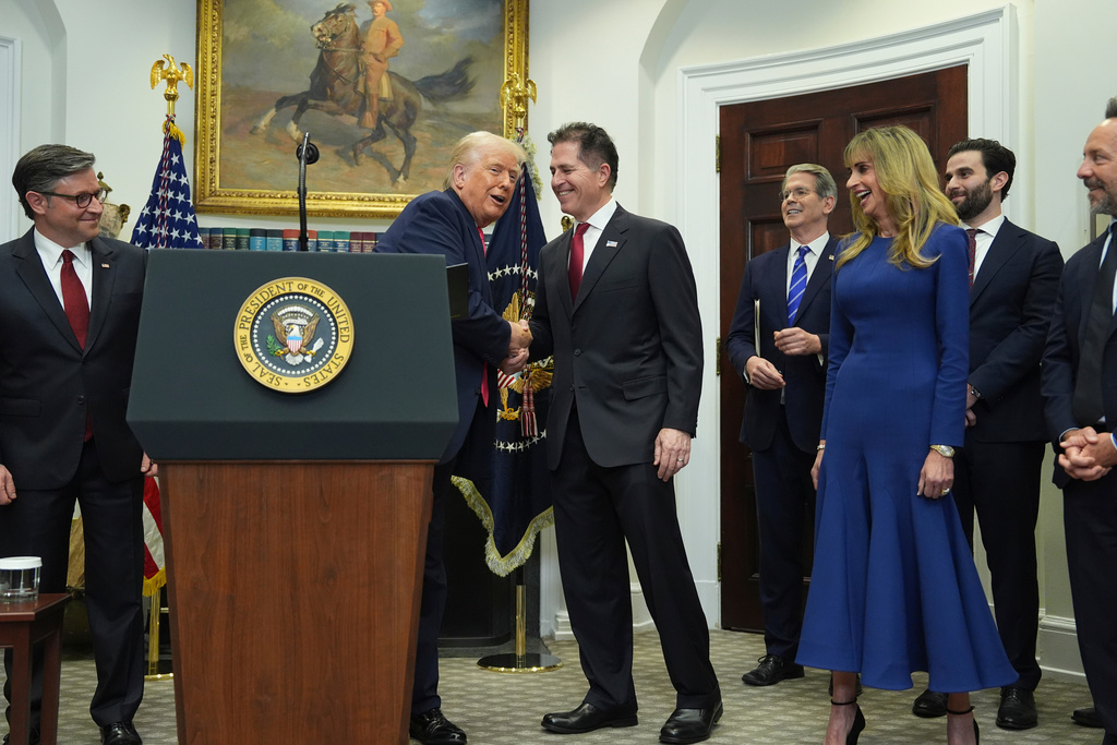 FILE - President Donald Trump shakes hands with Michael Dell as his wife Susan looks on, during an event on "Trump Accounts" for kids in the Roosevelt Room of the White House, Dec. 2, 2025, in Washington. (AP Photo/Evan Vucci, File)