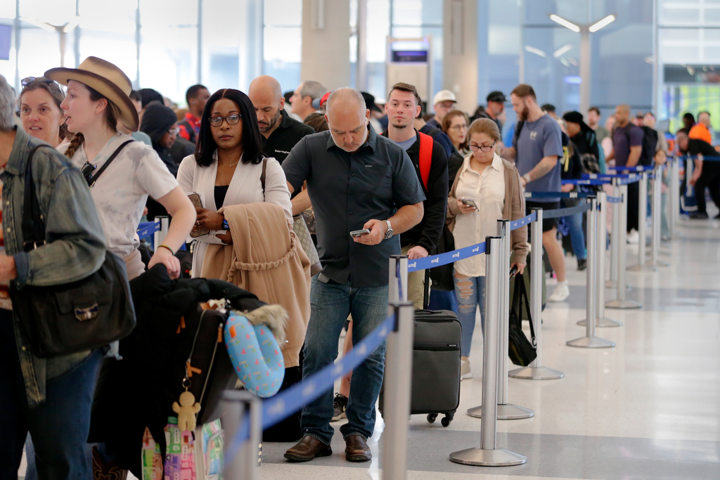 Air travelers endure long lines and two-hour wait times at the TSA security check point at Terminal E at the George Bush Intercontinental Airport Friday, March 20, 2026, in Houston. (AP Photo/Michael Wyke)