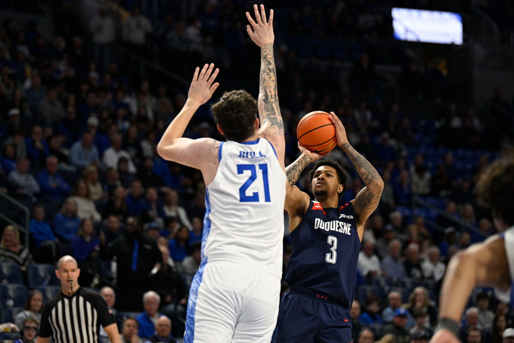 Duquesne's Jimmie Williams (3) shoots the ball as Saint Louis Billikens' Robbie Avila (21) defends during the first half of an NCAA college basketball game Saturday, Feb. 28, 2026, in St. Louis. (AP Photo/Jeff Le)