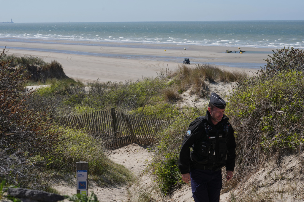 A French police officer walks on the beach of Zuydcoote, near Dunkirk, northern France, Thursday, April 23, 2026. (AP Photo/Michel Euler)