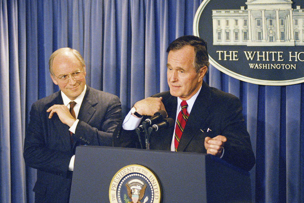 FILE - President George H.W. Bush gestures during a news conference at the White House on Friday, March 10, 1989, where he announced his selection of Rep. Richard Cheney, R-Wyo., left, to become Defense Secretary replacing his last choice of John Tower, whose nomination was turned down by the senate Thursday. (AP Photo/Charles Tasnadi, file)