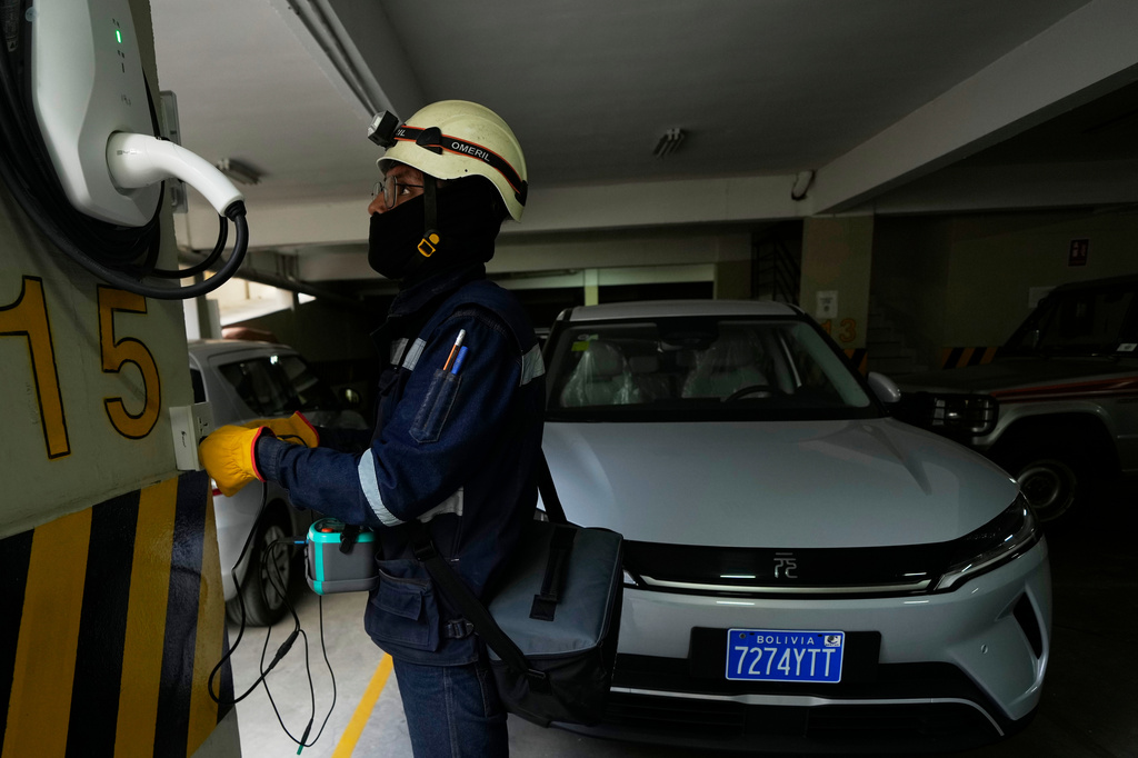 An electrician installs a home electric vehicle charging station in La Paz, Bolivia, Tuesday, April 21, 2026. (AP Photo/Juan Karita)