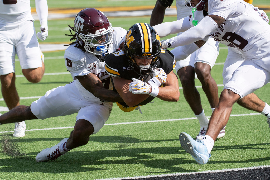 Missouri wide receiver Cayden Lee, center, scores past Texas A&M cornerback Julio Humphrey, left, during the first half of an NCAA college football game, Saturday, Oct. 10, 2026, in Columbia, Mo. (AP Photo/LG Patterson)