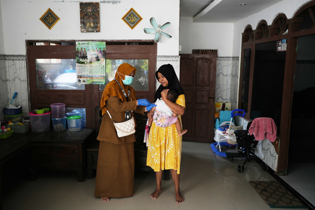 Health worker Siti Nurjanah administers a measles vaccination during a house-to-house campaign following an outbreak in Sumenep on Madura Island, Indonesia, Monday, Sept. 8, 2025. (AP Photo/Dita Alangkara)