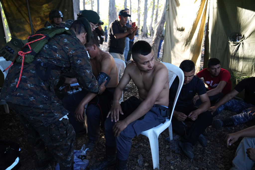 A medic checks on freed prison guards outside the Renovation maximum-security prison after security forces entered the facility to retake control in Escuintla, Guatemala, Sunday, Jan. 18, 2026. (AP Photo/Moises Castillo)