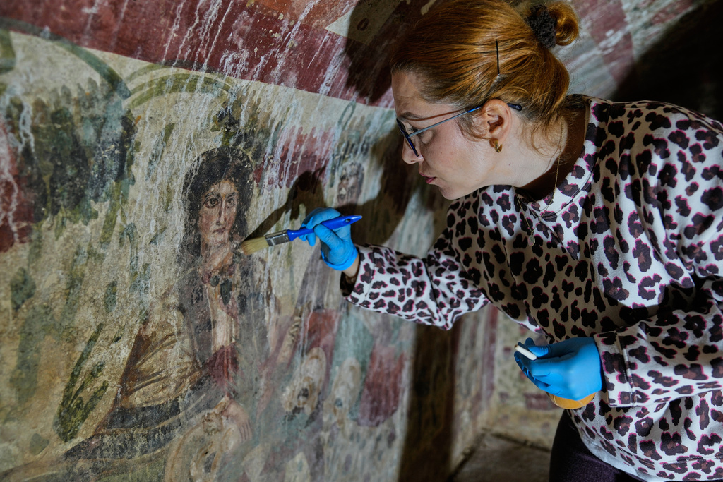 Archaeologist cleans and restores frescoes inside a 3rd-century tomb where a rare early Christian depiction of Jesus as the "Good Shepherd" was discovered, in Iznik, Turkey, Friday, Dec. 12, 2025. (AP Photo/Khalil Hamra)