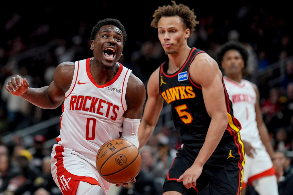 Houston Rockets guard Aaron Holiday (0) drives against Atlanta Hawks guard Dyson Daniels (5) during the first half of an NBA basketball game, Thursday, Jan. 29, 2026, in Atlanta. (AP Photo/Mike Stewart)