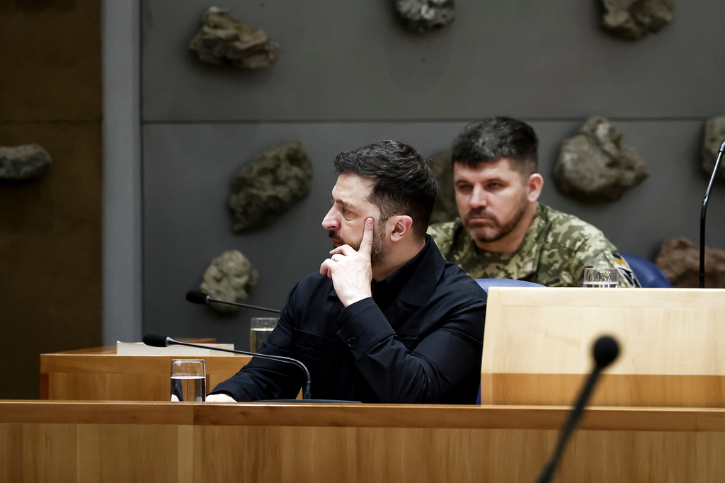 Ukraine's President Volodymyr Zelenskyy, front, attends a parliament session in The Hague, Netherlands, Tuesday, Dec. 16, 2025. (Robin van Lonkhuijsen/Pool Photo via AP)