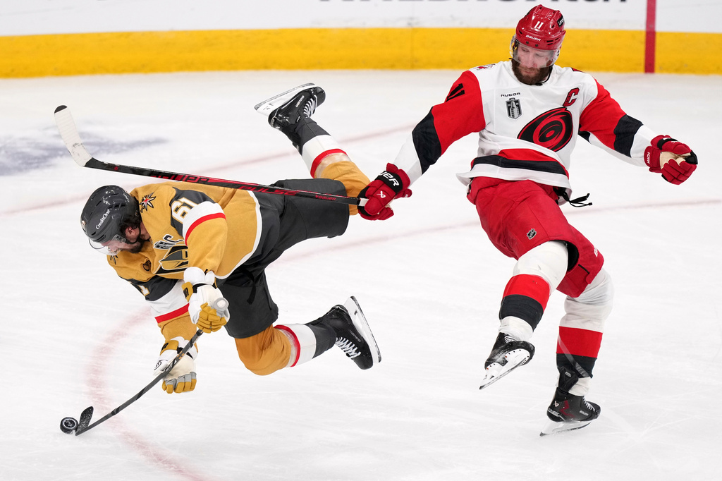 Vegas Golden Knights right wing Mark Stone, left, is checked by Carolina Hurricanes center Jordan Staal during the third period in Game 3 of the NHL hockey Stanley Cup Final series Saturday, June 6, 2026, in Las Vegas. (AP Photo/Candice Ward)