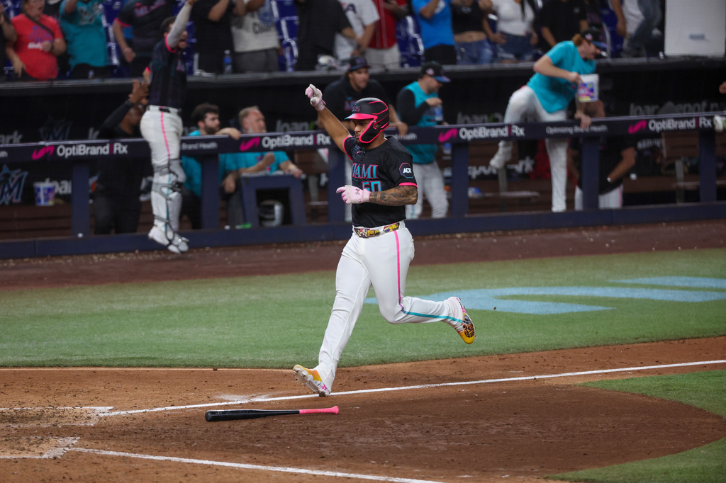 Miami Marlins designated hitter Agustín Ramírez (50) scores on a game-winning RBI single by Javier Sanoja during the ninth inning of a baseball game against the Washington Nationals, Friday, Aug. 21, 2026, in Miami. (AP Photo/David Santiago)