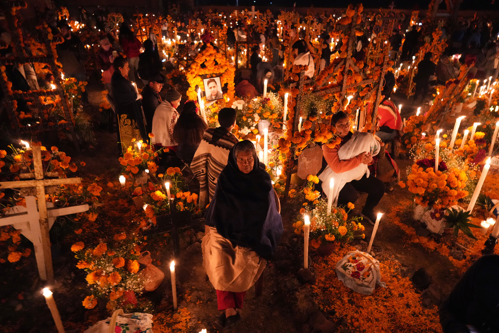 Families gather to keep company with their dearly departed celebrating the Day of the Dead at the cemetery in Arocutin, Michoacan state, Mexico, Saturday, Nov. 1, 2025. (AP Photo/Eduardo Verdugo)