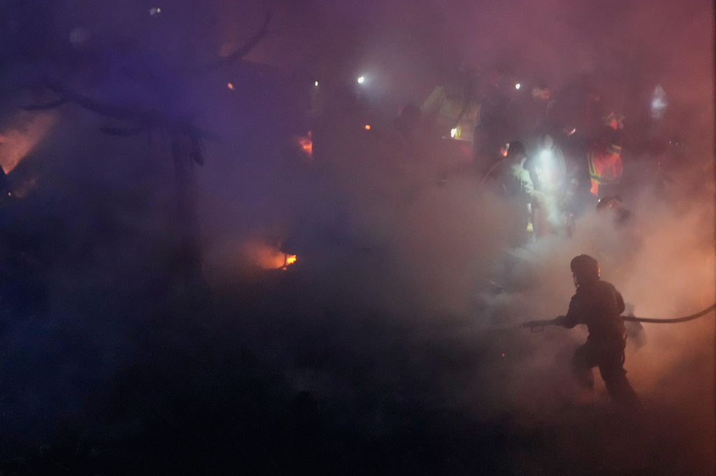 Firefighters and rescue workers inspect the site of Israeli airstrikes, in Beirut, Lebanon, Wednesday, April 1, 2026. (AP Photo/Hussein Malla)