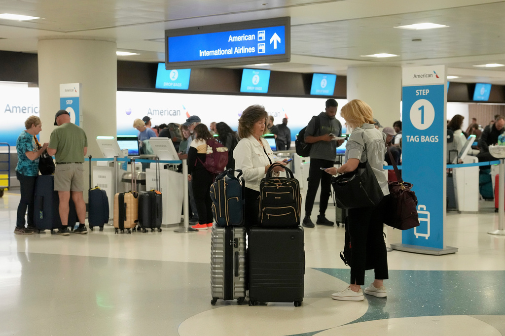 Passengers check in at the American Airlines ticket counter at Phoenix Sky Harbor International Airport Saturday, Nov. 8, 2025, in Phoenix. (AP Photo/Ross D. Franklin)
