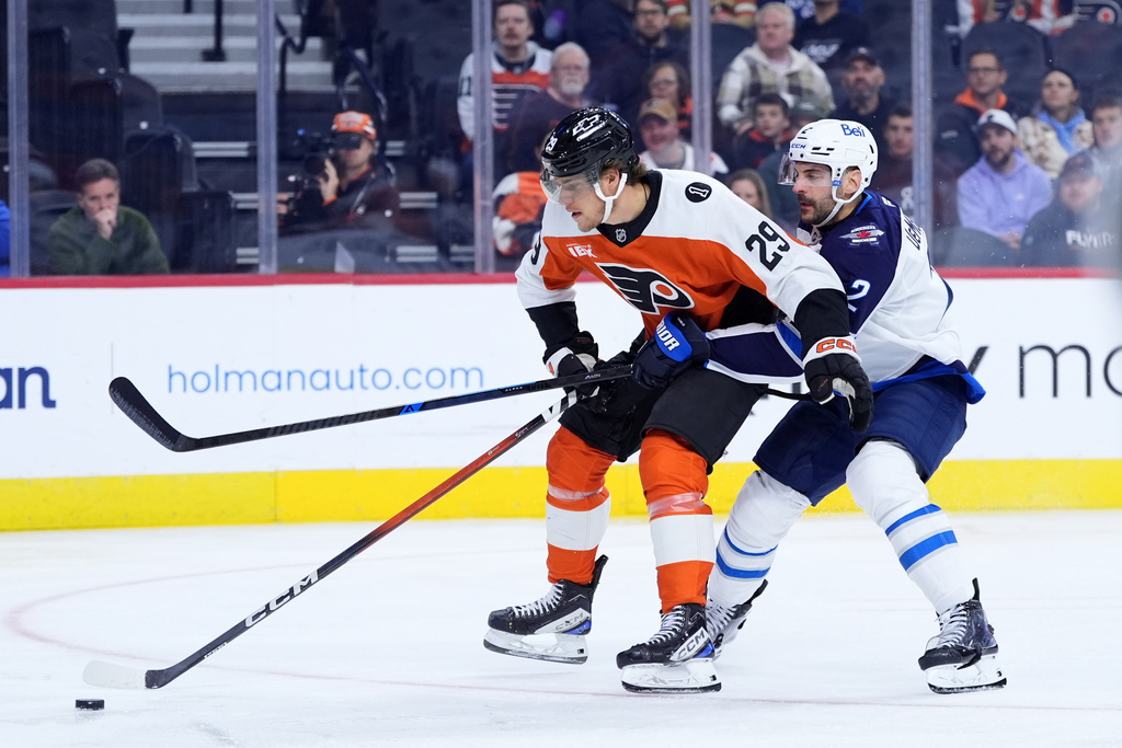 Winnipeg Jets' Dylan Demelo, right, holds Philadelphia Flyers' Nikita Grebenkin during the second period of an NHL hockey game, Thursday, Oct. 16, 2025, in Philadelphia. (AP Photo/Matt Slocum)