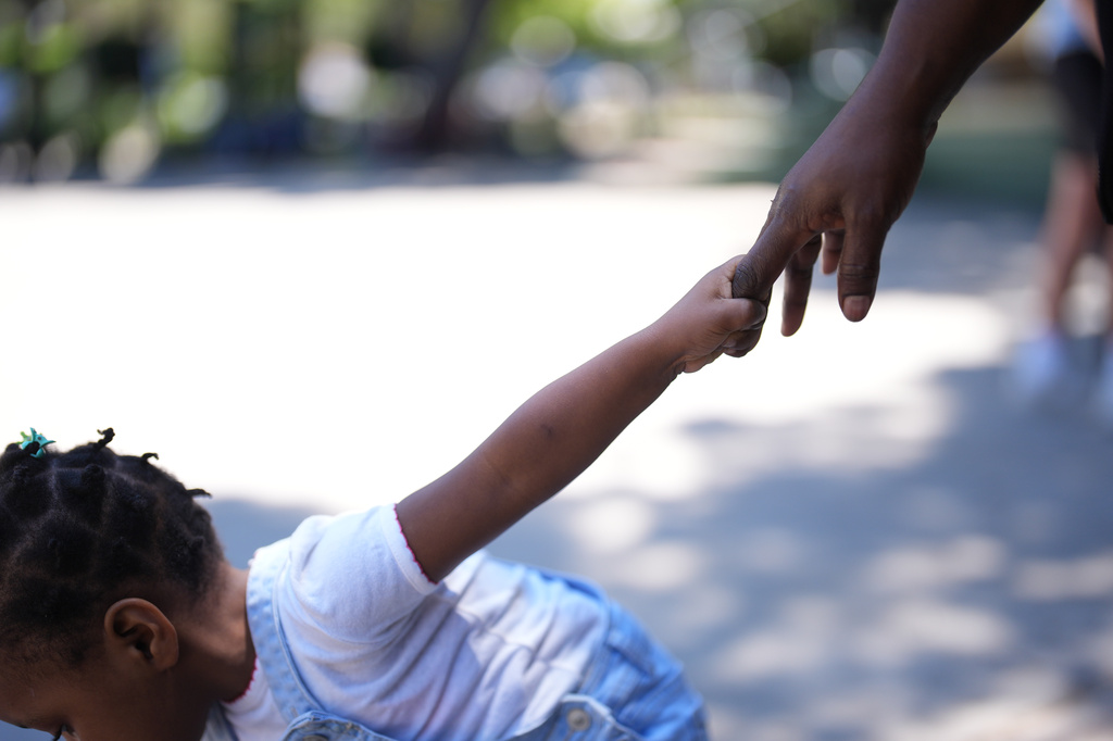 Vivianne Petit Frere holds the hand of her granddaughter Alexca at a park, June 22, 2026, in Tijuana, Mexico. (AP Photo/Gregory Bull)