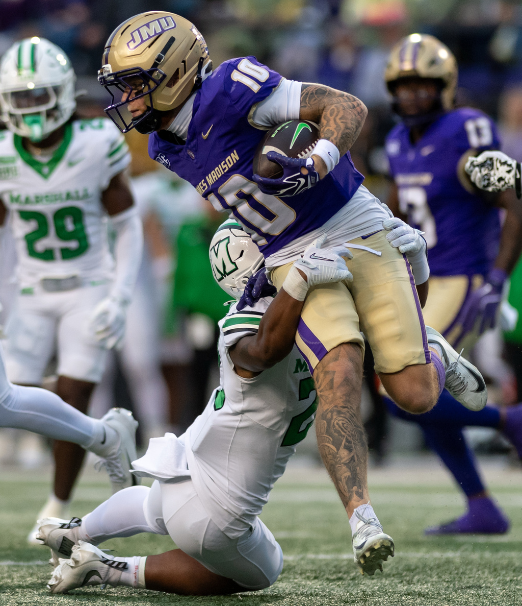 James Madison wide receiver Braeden Wisloski (10) sheds Marshall safety Jaycee Houston, bottom, on a kickoff return during the second half of an NCAA college football game in Harrisonburg, Va., Saturday, Oct. 3, 2026. (Daniel Lin/Daily News-Record Via AP)
