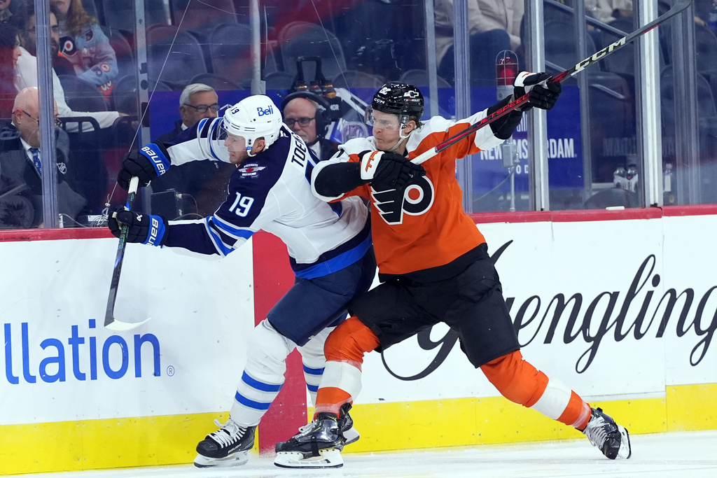 Philadelphia Flyers' Christian Dvorak, right, collides with Winnipeg Jets' Jonathan Toews during the third period of an NHL hockey game, Thursday, Oct. 16, 2025, in Philadelphia. (AP Photo/Matt Slocum)