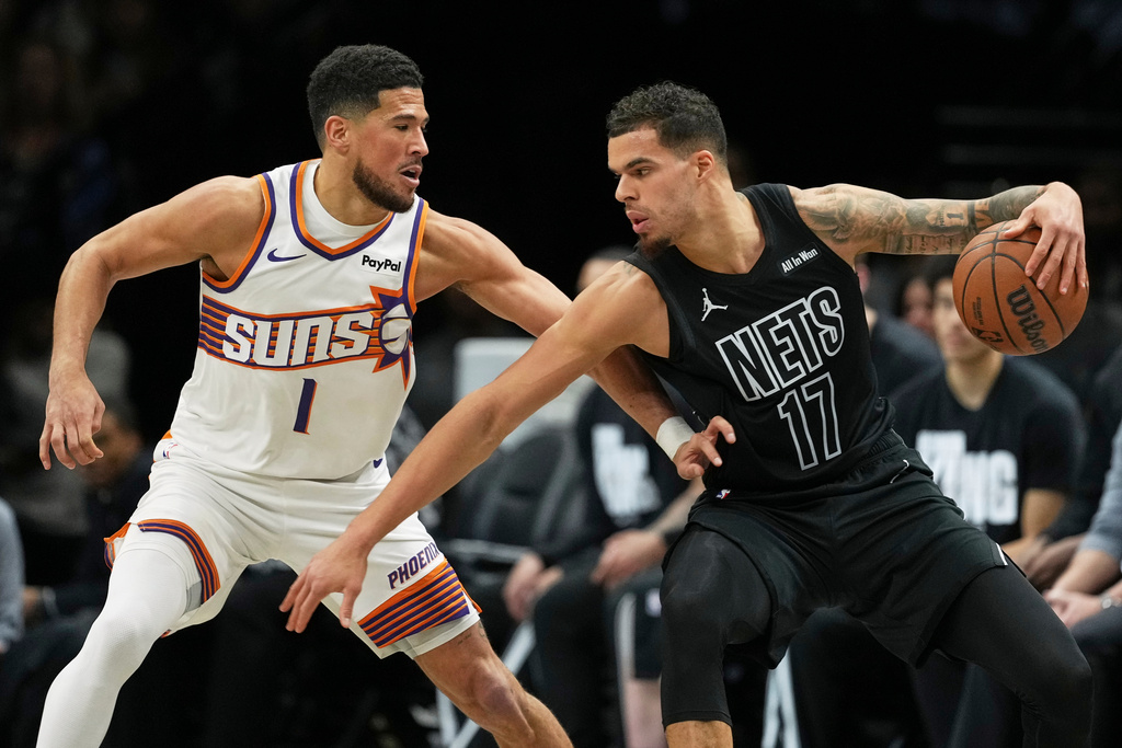 Phoenix Suns' Devin Booker (1) defends Brooklyn Nets' Michael Porter Jr. (17) during the first half of an NBA basketball game Monday, Jan. 19, 2026, in New York. (AP Photo/Frank Franklin II)