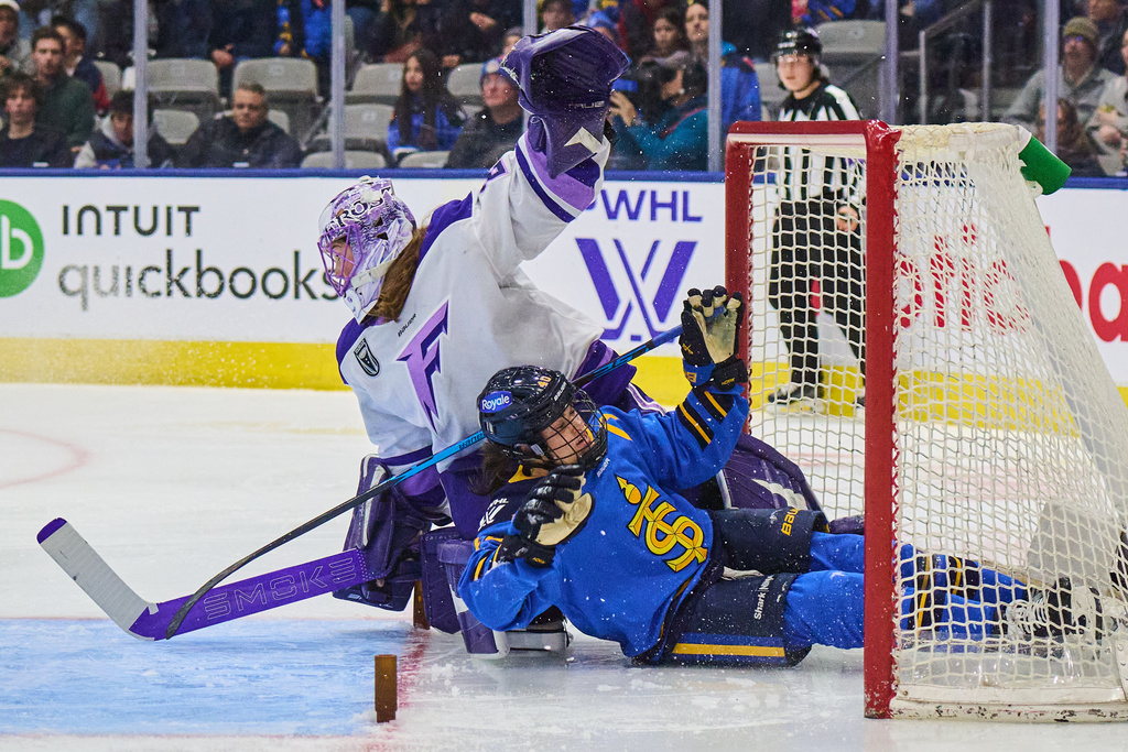Toronto Sceptres' Blayre Turnbull (40) crashes into the net as she collides with Minnesota Frost goaltender Nicole Hensley (29) during the second period of an PWHL hockey game in Toronto, on Tuesday, Dec. 30, 2025. (Sammy Kogan/The Canadian Press via AP)