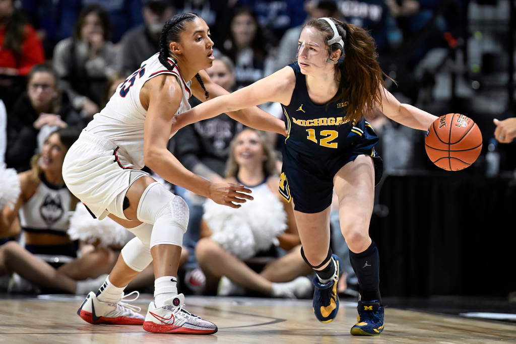 Michigan guard Syla Swords (12) is guarded by UConn guard Azzi Fudd in the first half of an NCAA college basketball game, Friday, Nov. 21, 2025, in Uncasville, Conn. (AP Photo/Jessica Hill)