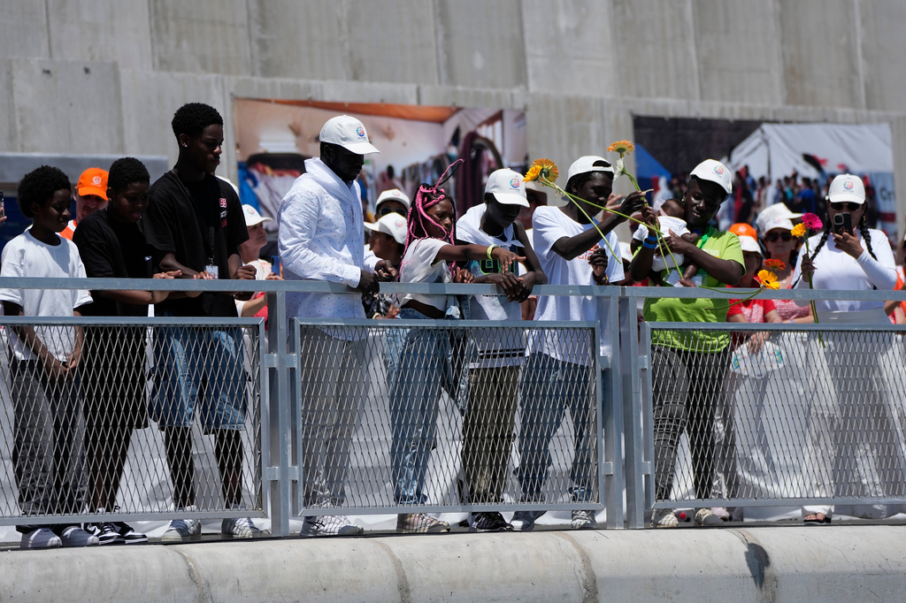 Faithful throw flowers into the sea as Pope Leo XIV attends a meeting with organisations working with migrants in Arguineguin at the Canary Islands, Spain, Thursday, June 11, 2026. (AP Photo/Alessandra Tarantino)