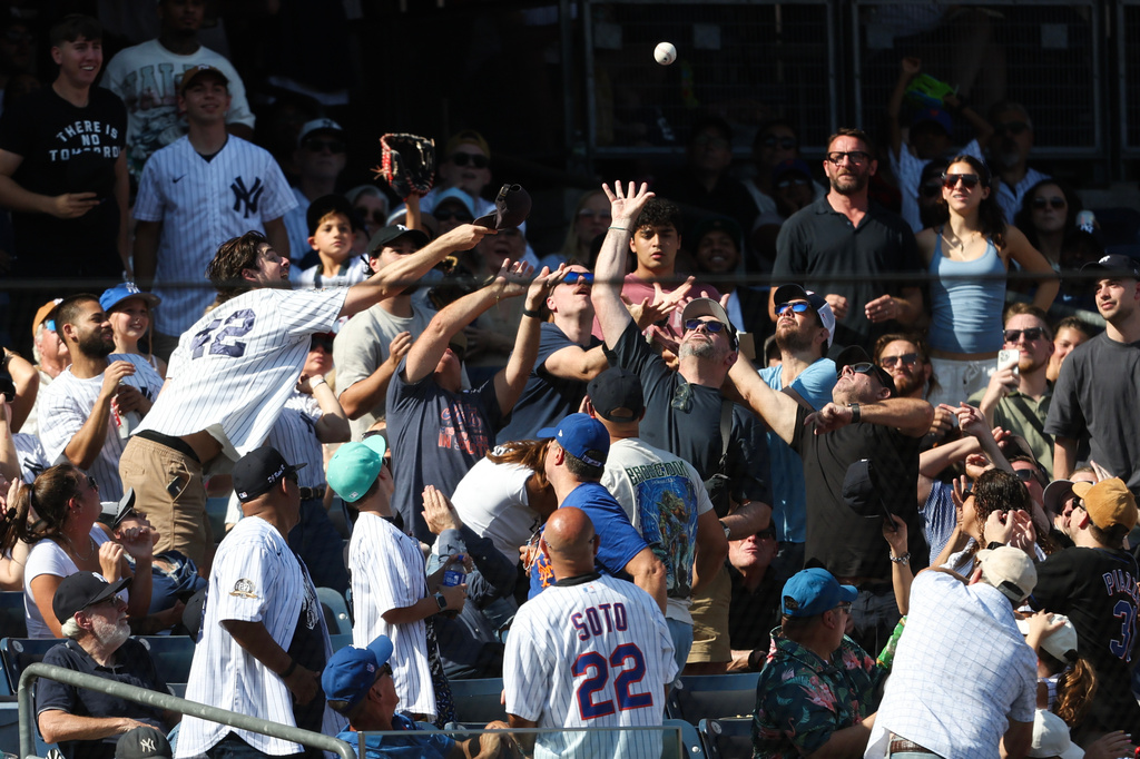 Fans reach up to catch a foul ball by New York Yankees' Cody Bellinger during the sixth inning of a baseball game against the New York Mets, Saturday, Sept. 12, 2026, in New York. (AP Photo/Heather Khalifa)