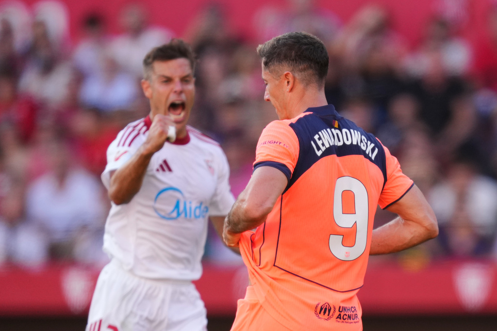 Sevilla's Cesar Azpilicueta, left, reacts after Barcelona's Robert Lewandowski, right, missed a scoring chance during the Spanish La Liga soccer match between Sevilla and Barcelona at the Ramon Sanchez Pizjuan stadium in Seville, Spain, Sunday, Oct. 5, 2025. (AP Photo/Jose Breton)