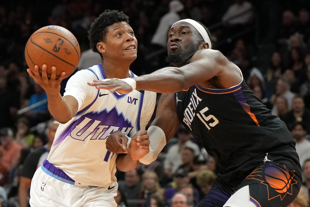 Utah Jazz forward Ace Bailey drives on Phoenix Suns center Mark Williams (15) during the second half of an NBA Cup basketball game, Friday, Oct. 31, 2025, in Phoenix. (AP Photo/Rick Scuteri)
