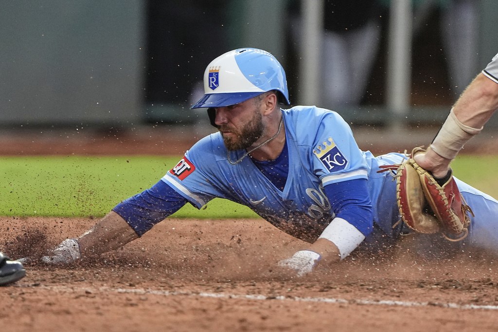Kansas City Royals' John Rave beats the tag by Chicago White Sox catcher Kyle Teel to score on a two-run double hit by Kyle Isbel during the fifth inning of a baseball game Saturday, Aug. 16, 2025, in Kansas City, Mo. (AP Photo/Charlie Riedel)