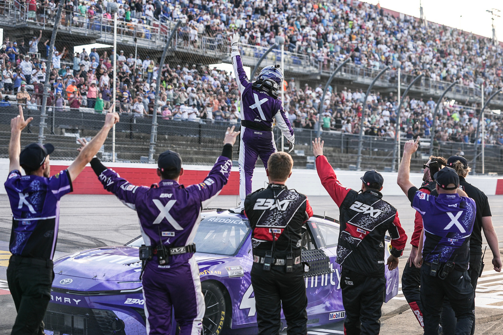 Tyler Reddick stands on top of his car and celebrates with his team after winning a NASCAR Cup Series auto race, Sunday, March 22, 2026, in Darlington, S.C.(AP Photo/Matt Kelley)