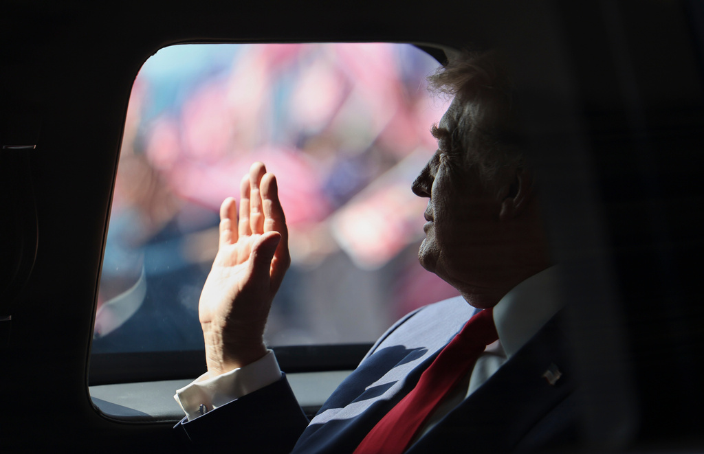 U.S. President Donald Trump waves from his official vehicle as he heads to attend the 47th Association of Southeast Asian Nations (ASEAN) summit after arriving at Kuala Lumpur International Airport in Kuala Lumpur, Malaysia, Sunday, Oct. 26, 2025. (Hasnoor Hussain/Pool Photo via AP)