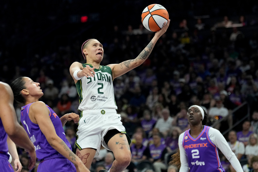Seattle Storm guard Natisha Hiedeman (2) drives past Phoenix Mercury forward Noemie Brochant (1) and Mercury forward Kahleah Copper (2) to score during the first half of a WNBA basketball game, Saturday, June 20, 2026, in Phoenix. (AP Photo/Ross D. Franklin)